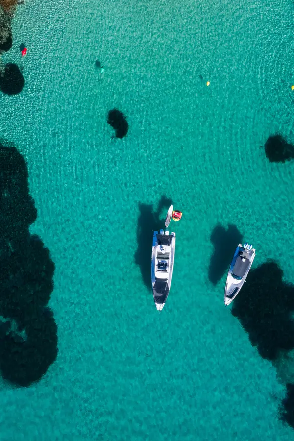 Modern Axopar 37 cabin boats moored together in calm, turquoise waters of the Cretan harbor.